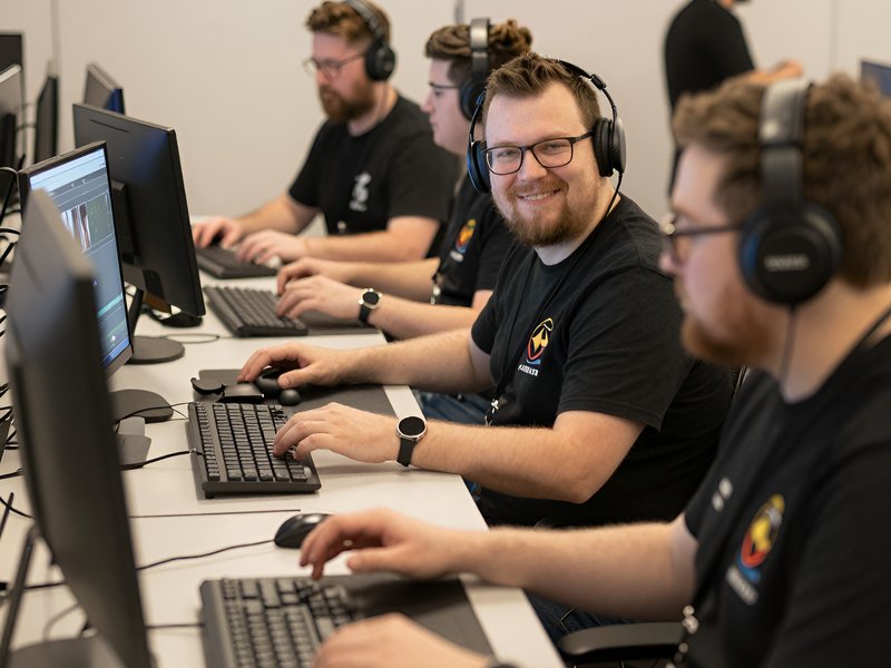 Команда разработчиков читов для Counter-Strike Source работает за компьютерами в современном офисе
